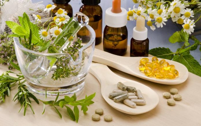 Alternative Medicine. herbs in a glass mortar. Essential oils and herbal supplements.